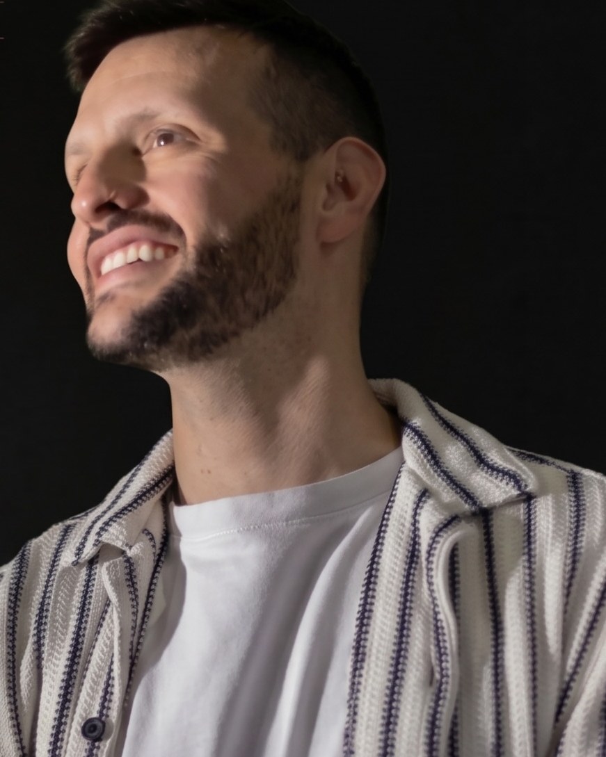Pedro Nantes de camisa listrada, olhando para cima e sorrindo. Foto do post dele de 25 de setembro.